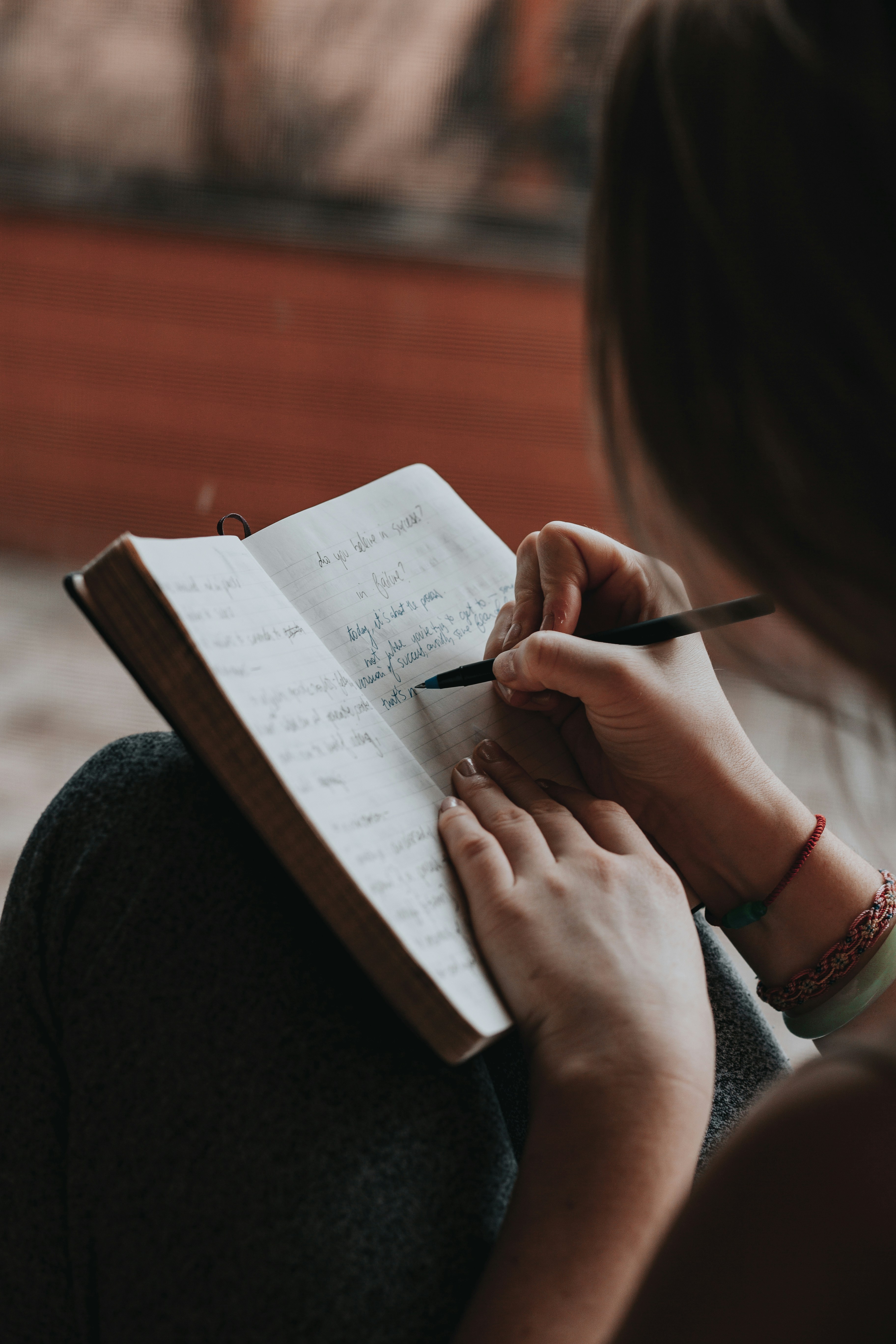 A person journaling quietly with a pen and notebook